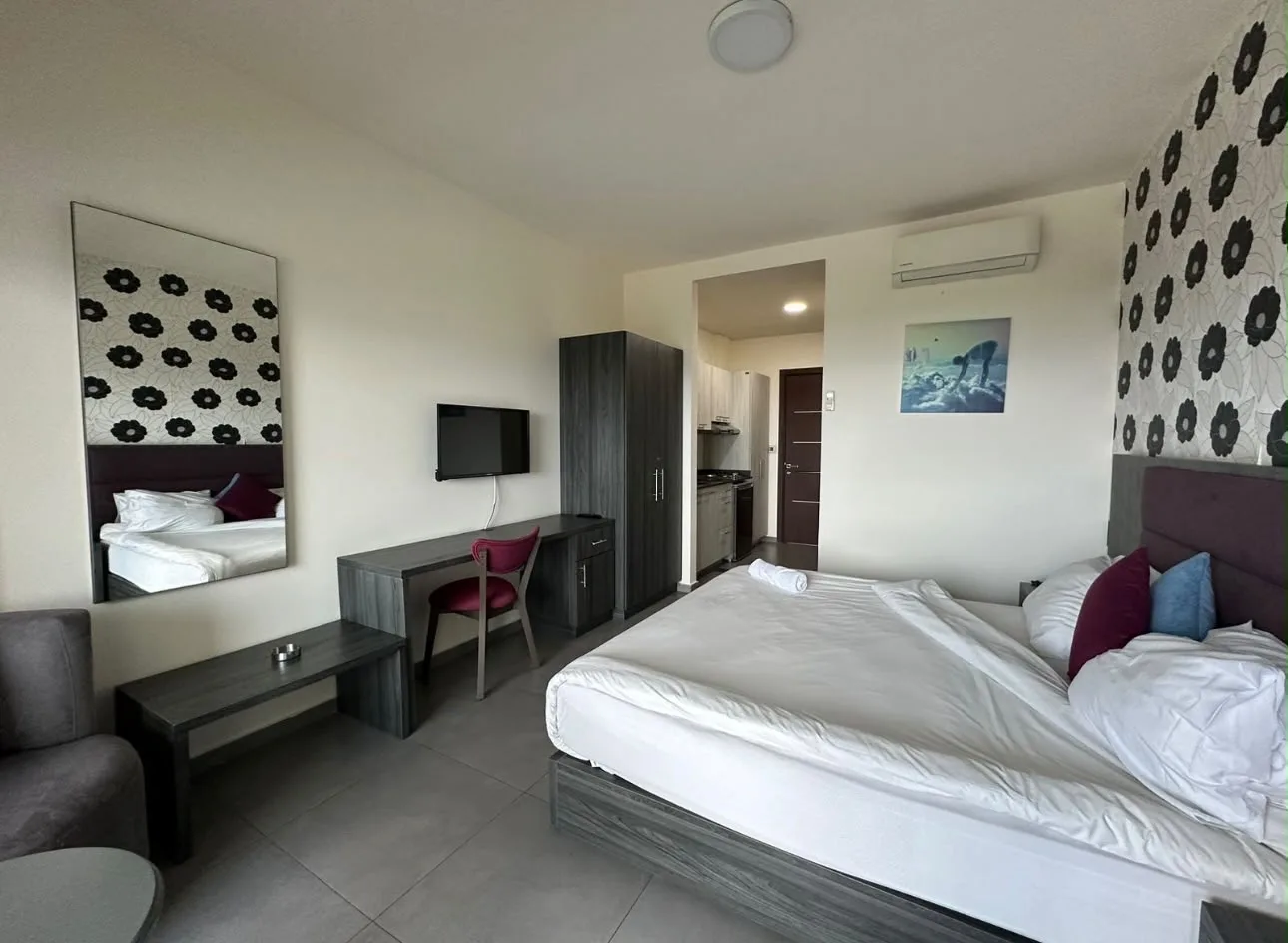 Guest room with a desk and kitchenette